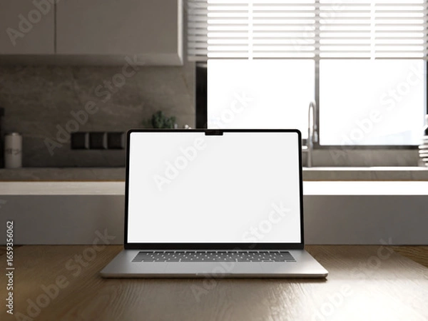 Fototapeta Elegant laptop mockup on a table in a modern kitchen, ideal for website presentation.