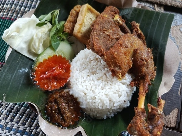 Fototapeta The traditional dish penyetan wader and Chicken refers to wader fish that is fried crispy and then crushed with spicy chili sauce, and traditional woven fish as a serving method or garnish. 