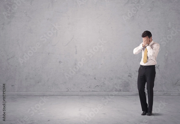 Fototapeta Young businessman standing confused