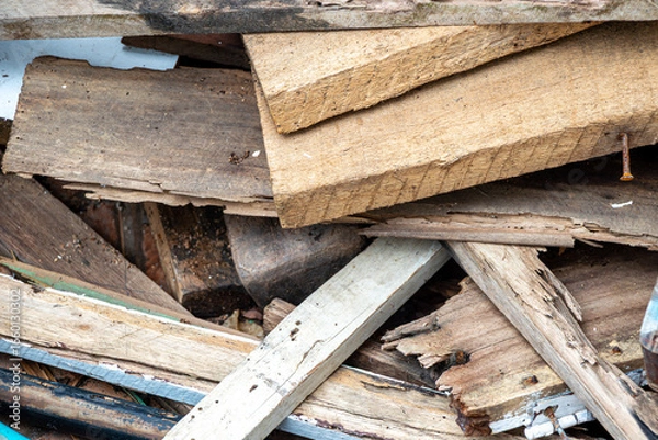 Fototapeta Construction waste after dismantling, a pile of wood stacked on a vacant lot for construction purposes, old wooden window and door frames.