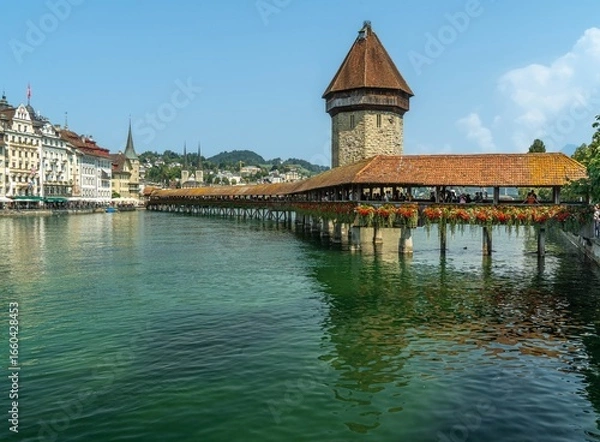 Fototapeta The Kapellbrücke ('Chapel Bridge') a wooden footbridge over river Reuss in the city of Lucerne in Switzerland in a sunny day.