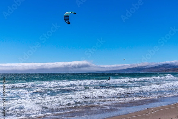Fototapeta Lompoc, CA, USA – August 13, 2025: Kitesurfers take advantage of the high winds on the Pacific Ocean at Jalama Beach in Lompoc, CA.