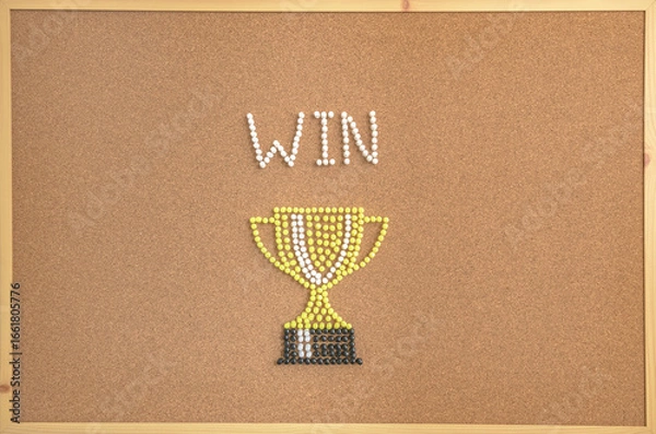 Fototapeta A creative concept image of a trophy cup and the word “WIN” designed with colorful push pins on a corkboard. The composition symbolizes victory, achievement, motivation, competition, and success. 