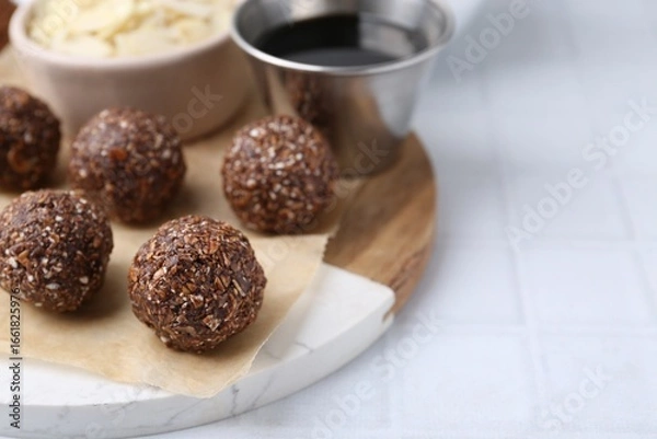 Fototapeta Making homemade candies. Chocolate balls and ingredients on white tiled table, closeup. Space for text