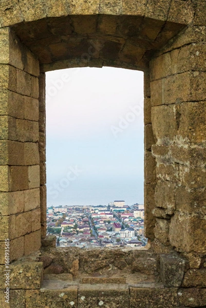 Fototapeta Derbent, Dagestan, Russia - 24 October 2020: Aerial view over the town of ancient city of Derbent through the window in Derbent fortress