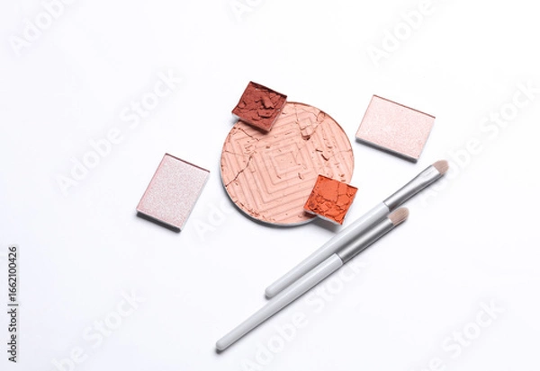 Fototapeta Crushed eyeshadow for makeup and brushes. Cosmetic product sample on white background. Creative layout. Beauty make concept. Top view