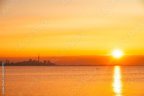 Fototapeta Toronto skyline in the morning. Silhouette figure of a man enjoying the Toronto sunrise