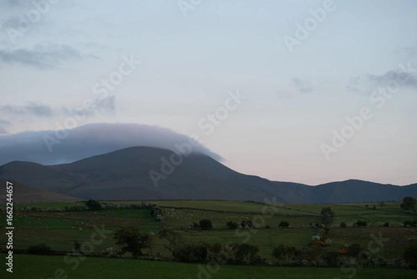 Fototapeta Twilight Over Mist-Capped Mountains and Peaceful Pastures