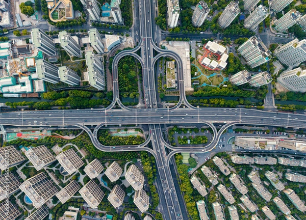 Fototapeta Aerial top down view of a busy junction reveals a multitude of vehicles traveling on various roadways. Hangzhou, China.