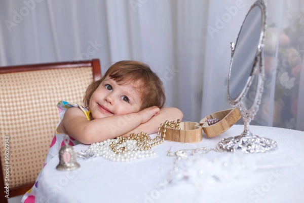 Obraz Маленькая девочка примеряла драгоценности перед зеркалом и задумалась, мечты