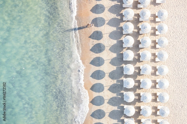 Fototapeta Aerial view of white beach, umbrellas and turquoise clear water during sunset, Mediterranean sea, Sardinia, Italy,