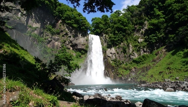 Fototapeta Lush waterfall cascading down rocky cliffs