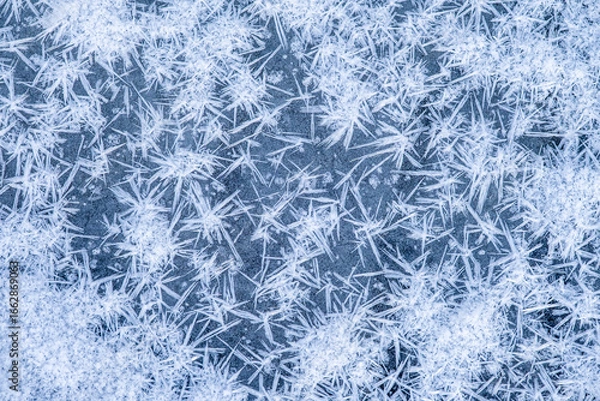 Fototapeta Beautiful pattern on the surface of a reservoir in cold weather. Winter background with frozen water. Christmas motifs