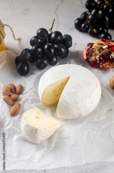 Obraz Camembert cheese with white mold, walnuts, honey and dried fruits. Dinner or aperitif concept.