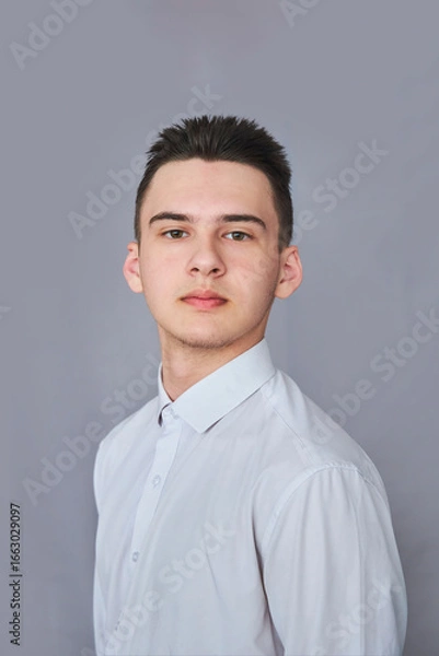 Fototapeta A high school student in uniform on a gray background.