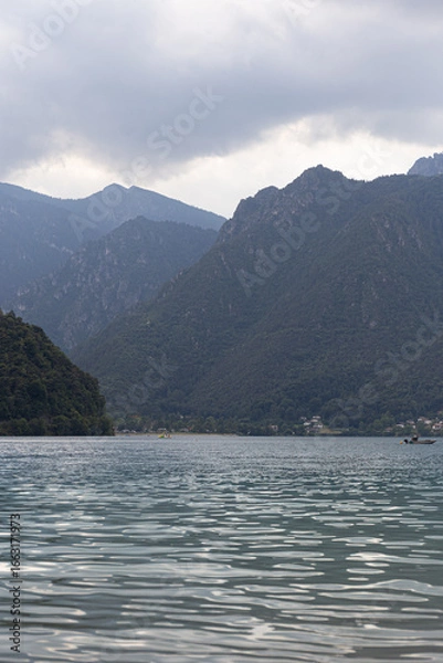 Fototapeta A picturesque and tranquil view of a lake nestled in a mountain valley. Perfect for travel blogs, wellness content, or concepts of a natural escape. Vertical shot.