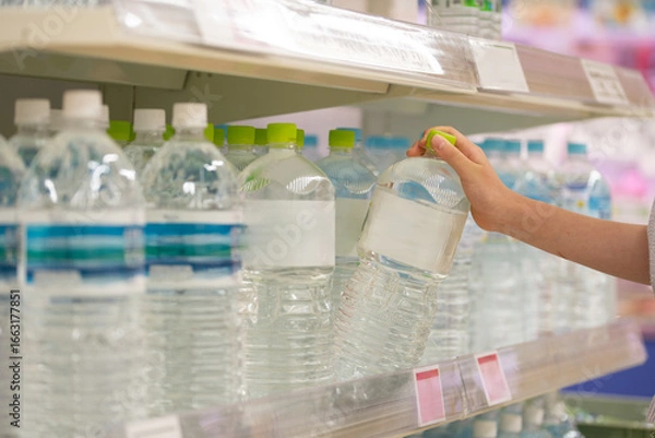 Fototapeta ペットボトル入りの飲料水を買う客の手元