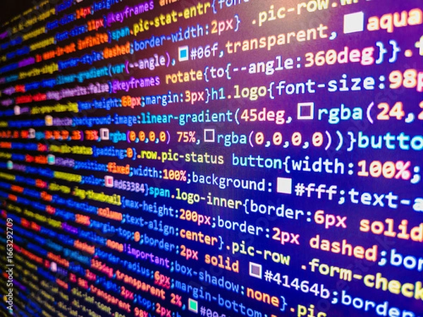 Fototapeta Abstract laptop screen of web developer. Developer working on program codes. Minificated web development javascript code close up in sunset rays