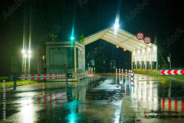Fototapeta Danish border checkpoint at night in rain with glowing green traffic lights