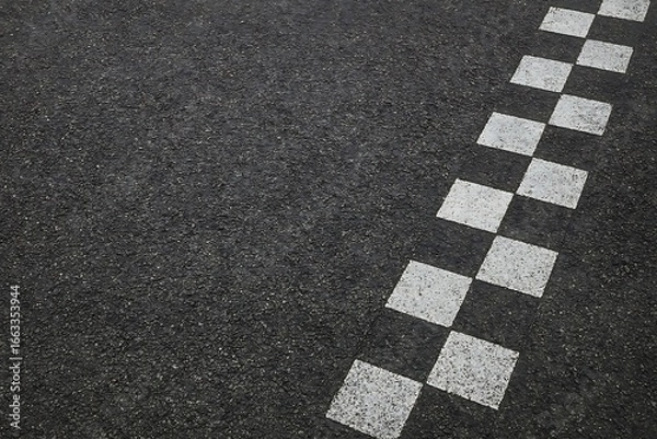 Obraz A close-up displays a textured asphalt surface adorned with white, checkered square pattern design.