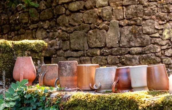 Obraz Poteries Jarres décoratives sur mur en pierre