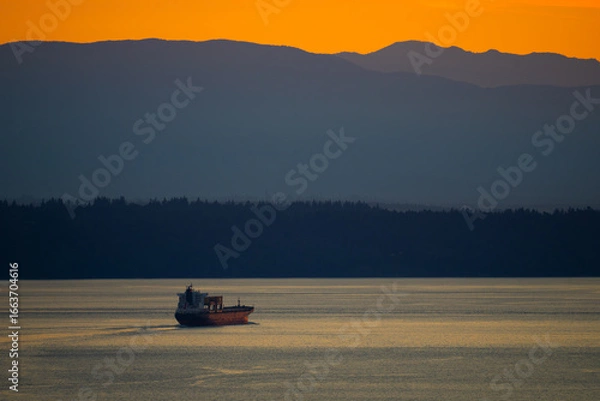 Fototapeta Cargo Ship Exits Puget Sound at Dusk
