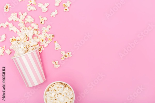 Fototapeta Popcorn bucket on pink background. Movie or TV background. Top view Copy space