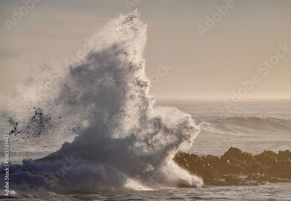 Fototapeta huge waves crashing on rocky beach