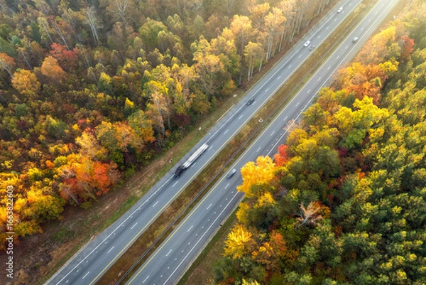 Fototapeta Elevated view of freeway road lanes between autumn mountain hills. Interstate transportation infrastructure in USA