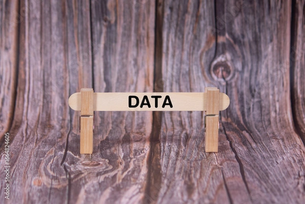Fototapeta Data symbol. A wooden stick clasped by clothespins set over a beautiful Brown Grunge Wooden Texture Background. Business and Data concept with copy space