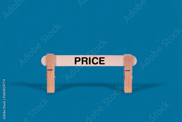 Fototapeta Price symbol. Single Wooden stick confined by  Clothespins, Cool Blue Background. Business and Price concept with copy space