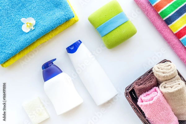 Fototapeta Bath accessories. Towels, soap, shampoo, washclothes on white background top view copyspace