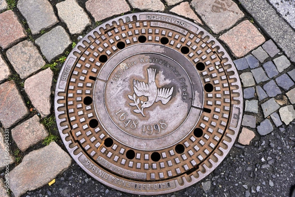 Fototapeta Kanaldeckel mit Friedenstaube in Münster als Erinnerung an den Westfälischen Frieden, der 1648 den 30 Jährigen Krieg beendete