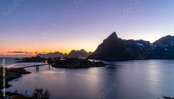 Fototapeta A tranquil harbor scene at sunset, showcasing a picturesque bridge connecting islands, surrounded by dramatic mountains and a calm body of water.