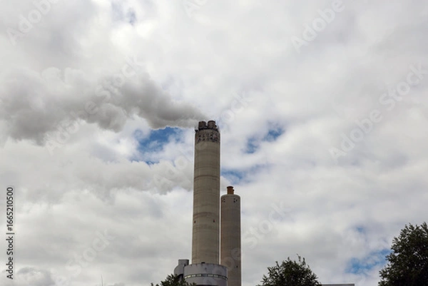 Fototapeta Amsterdam, The Netherlands - August 23rd, 2025 - Steam from the chimneys of waste incinerator AEB in Westpoort harbor