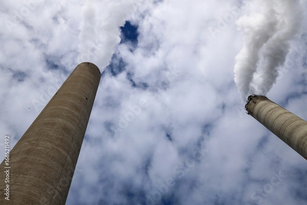 Fototapeta Amsterdam, The Netherlands - August 23rd, 2025 - Steam from the chimneys of waste incinerator AEB in Westpoort harbor
