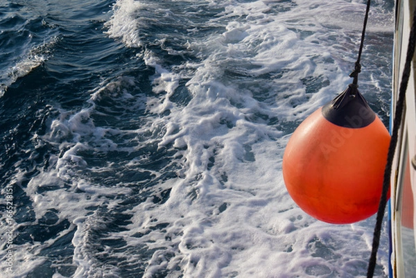 Fototapeta Roter Fender / roter Kugelfender an einem fahrenden Schiff