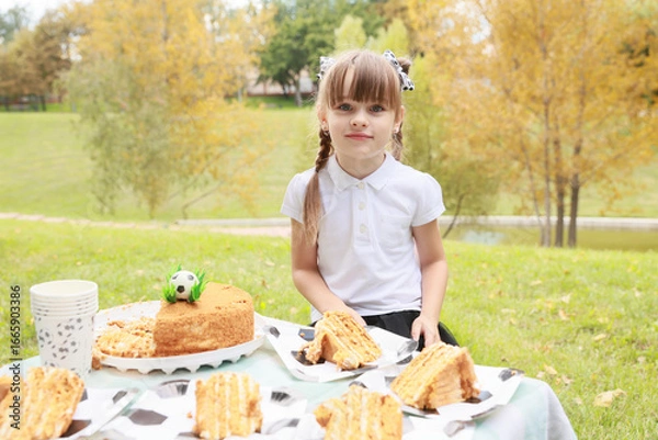 Obraz Celebration of Joy and Laughter in a Sunny Park With Cake and a Little Girl During a Festive Afternoon Picnic