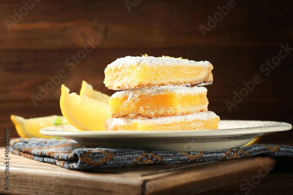 Fototapeta Delicious lemon pie bars stack on wooden background,closeup