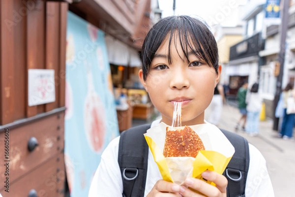 Fototapeta 鎌倉観光をしながら食べ歩きをする10代の女性