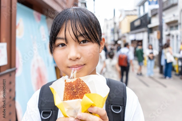 Fototapeta 鎌倉観光をしながら食べ歩きをする10代の女性
