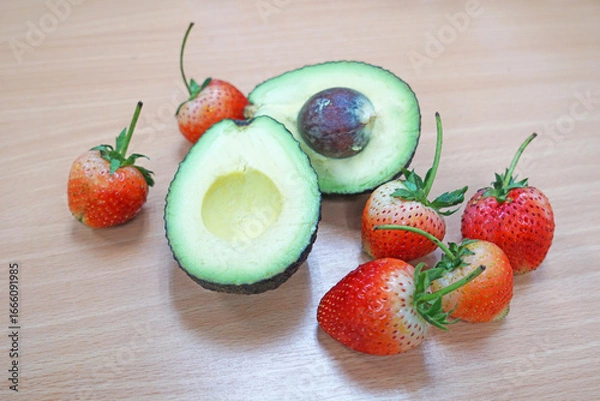 Fototapeta Fresh avocado and strawberries on the table.