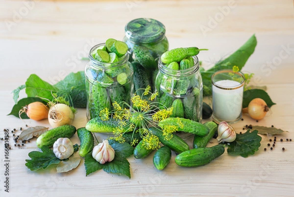 Fototapeta Lightly salted homemade cucumbers in a jar on a wooden background. Pickled cucumbers with dill, garlic and pepper. Canned cucumbers. Cucumbers with dill. Recipe for home canning. Fermented product