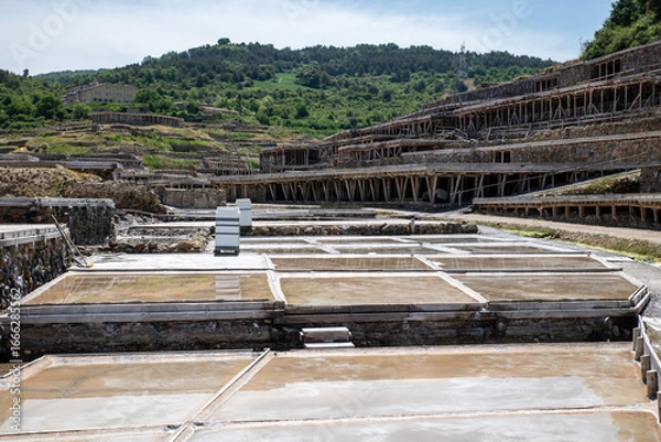 Fototapeta Authentic salt flats showcasing salt winning pools with individuals observing the process