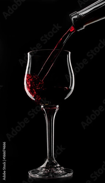 Obraz a glass of red wine which is poured on a black background