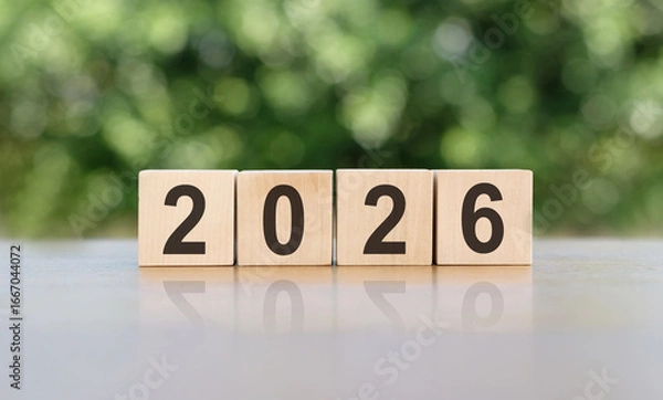 Fototapeta 2026 on natural wooden cube highlighted by the sun, Concept to welcome the New Year 2026