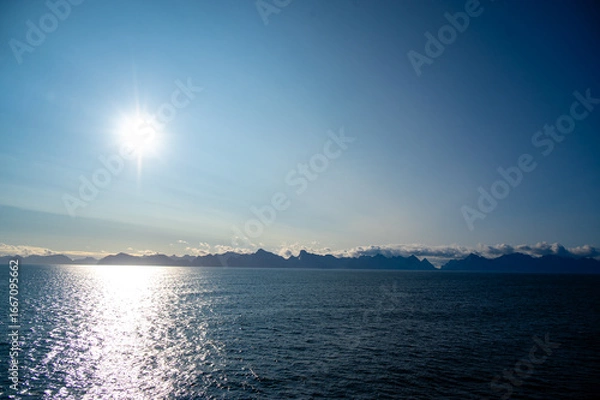 Fototapeta The sun reflects in the fjord near the Lofoten Islands in Norway in summer