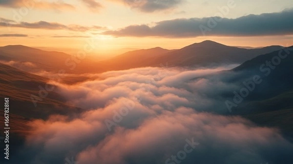 Fototapeta Mountain range with fog and clouds at sunset, aerial view
