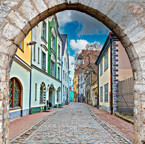 Obraz Narrow street with stone arch in old town