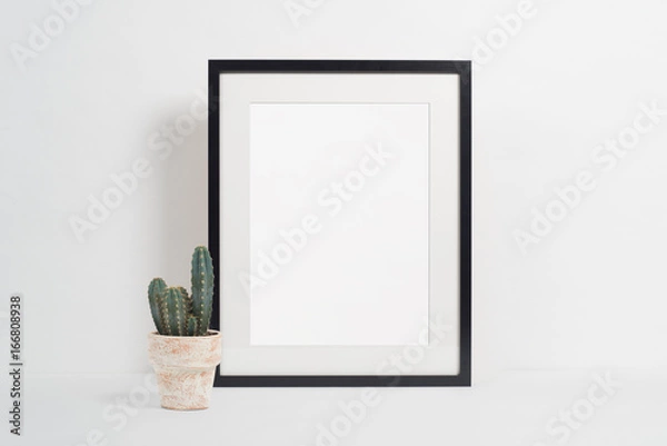 Fototapeta Black picture frame on white background with plant pot